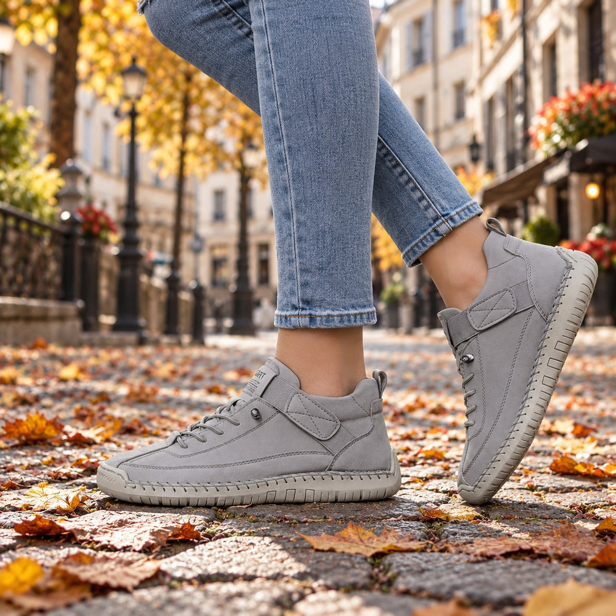 MAYA in Grau, getragen auf Kopfsteinpflaster im Herbstlaub